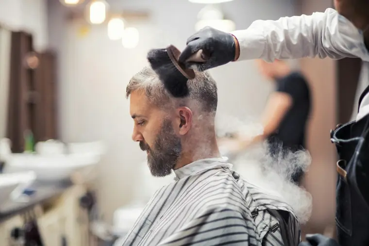 Barbier apportant la touche finale au soin d’un client