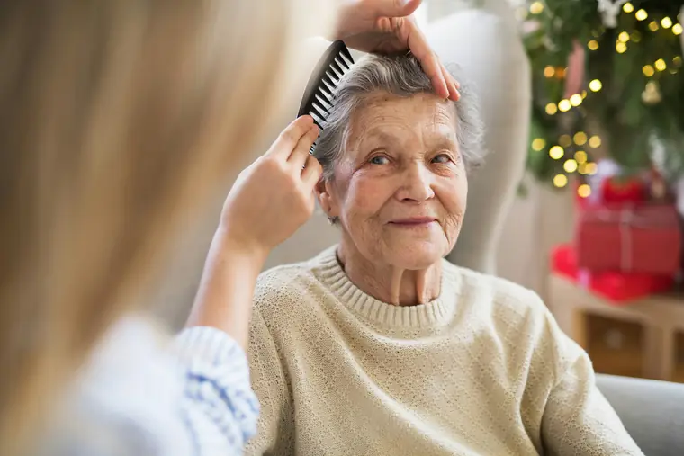 Coiffeuse indépendante intervenant auprès d’une cliente âgée à domicile